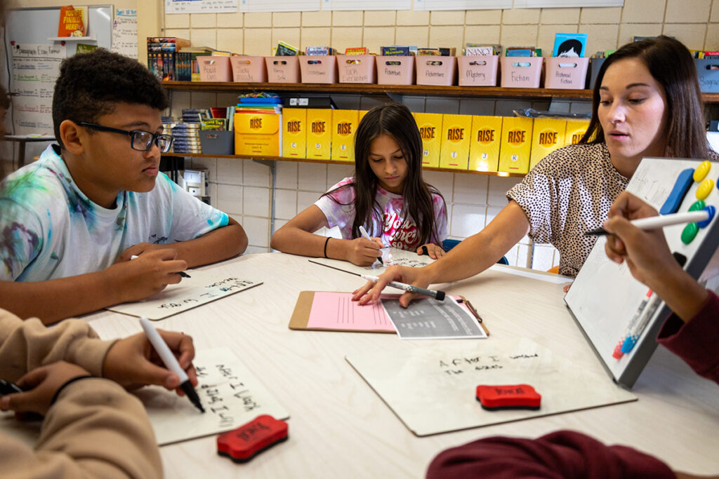 Elementary Teacher teaching students writing on an erasable white board