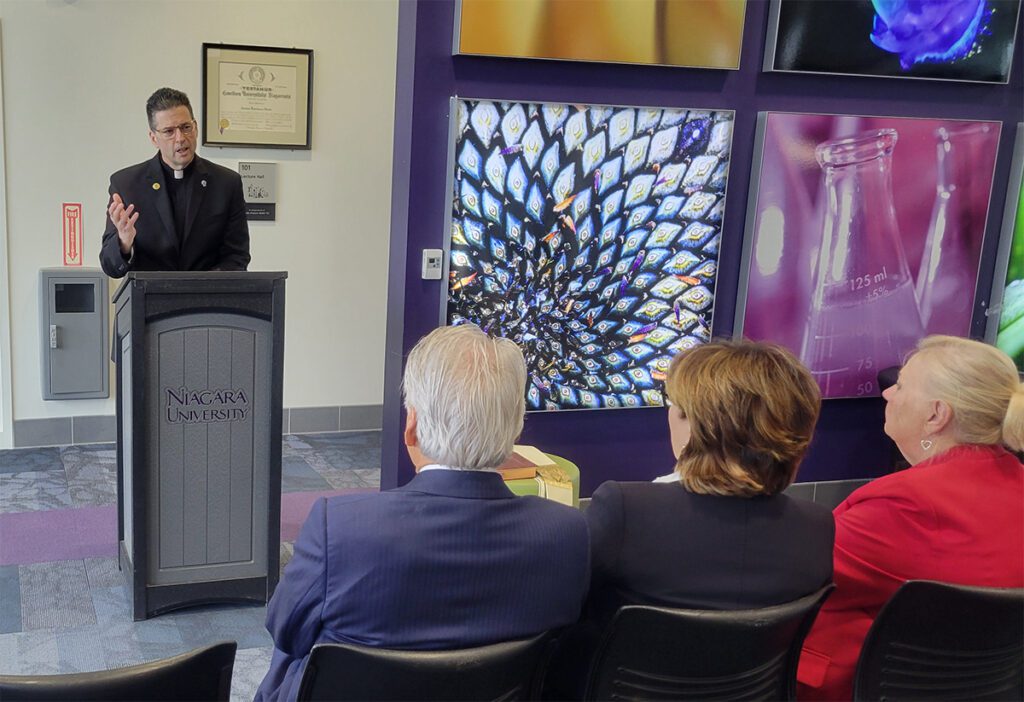 The Rev. James J. Maher, Niagara University president, dedicates a room in the university’s B. Thomas Golisano Center for Integrated Sciences in honor of John Francis Walsh, NU Class of 1943.