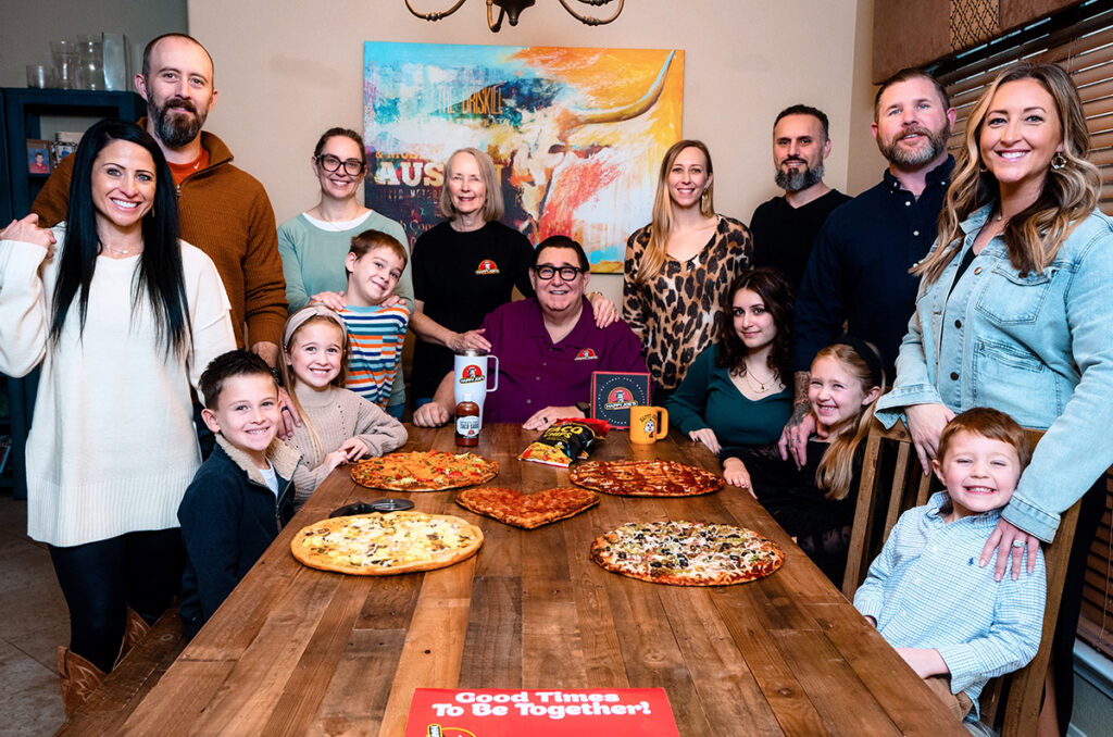 Sacco family around table with pizza