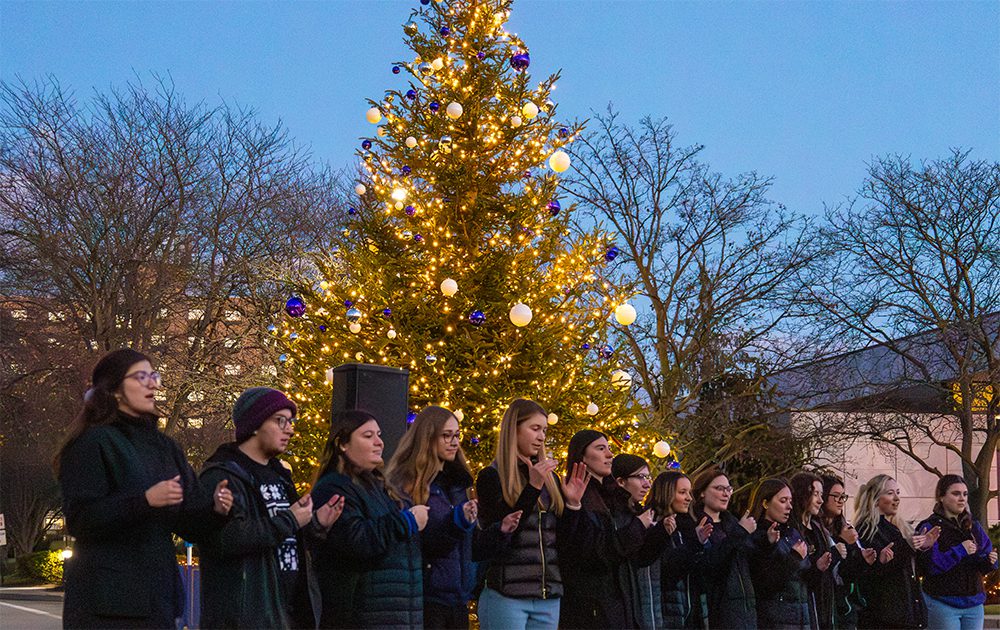 Students standing in front of the christmas tree during the lighting ceremony