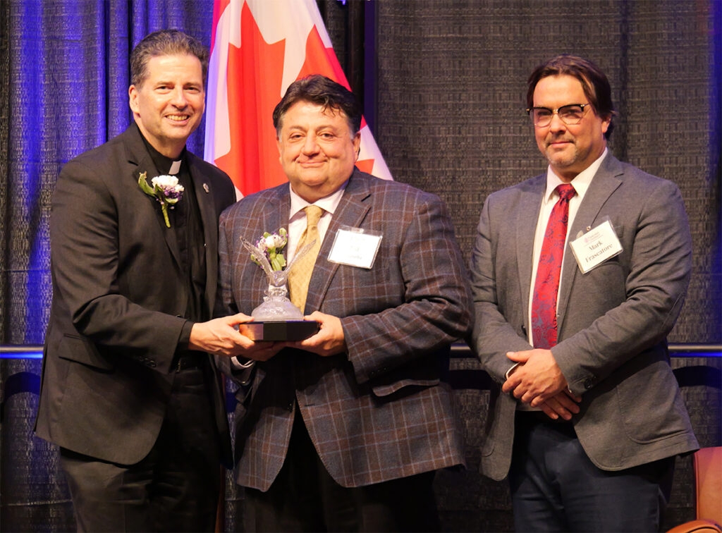 The Rev. James Maher, C.M., Niagara University president, presents the Dean's Award to Bill Chiodo