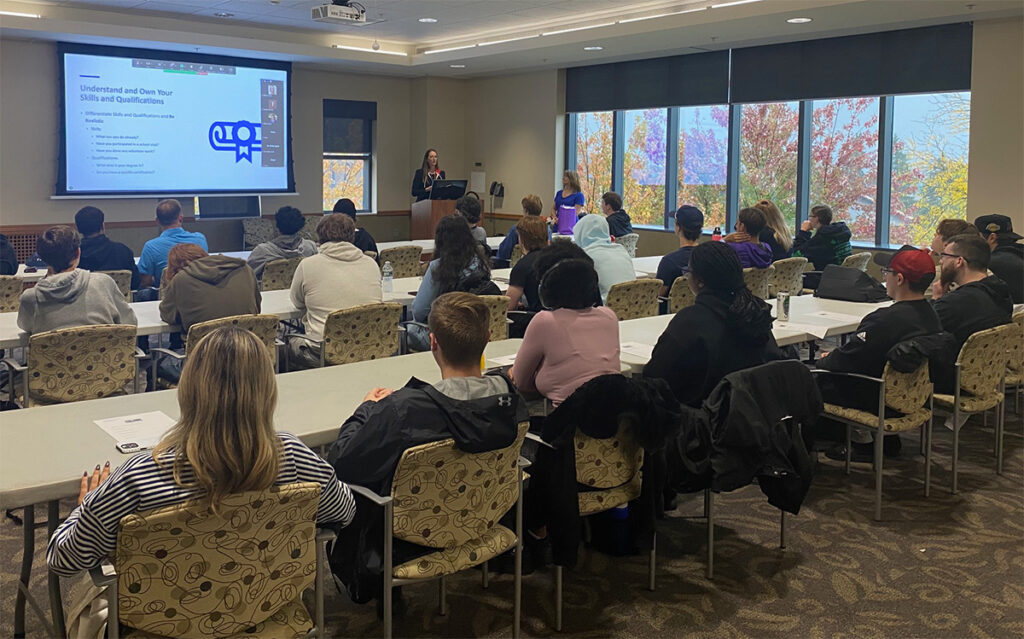 Lisa Catanese, director of human resources at West Herr Automotive Group, lectures in a room with Niagara University business students.