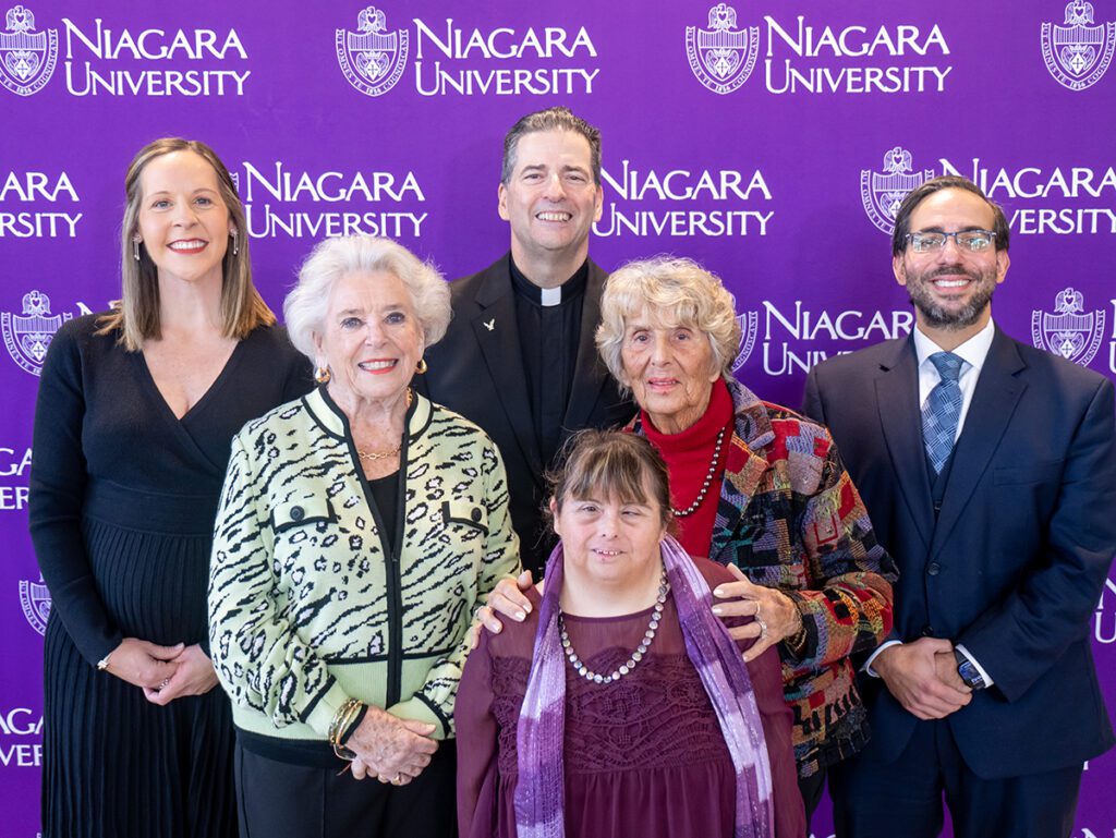 Niagara University officials and friends in front of a purple background