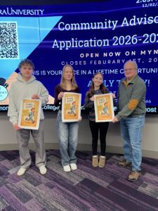 Three college students holding Get Out of the Final Exam Free cards and their professor