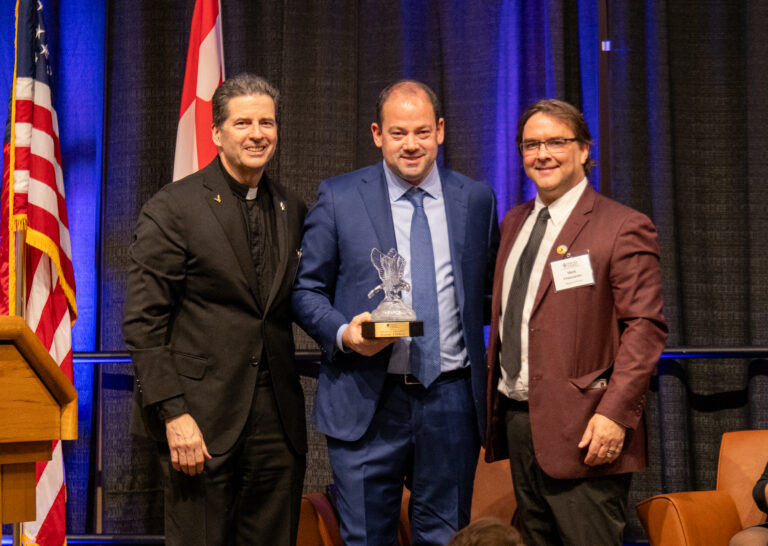 Jamie Obletz, executive vice president and chief operating oﬃcer of Delaware North, receive the Dean's Award from Father Maher and Dr. Mark Frascatore.