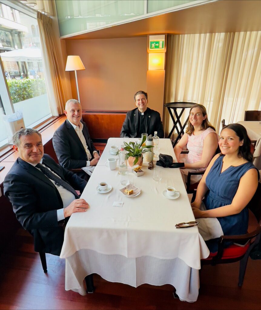 Sammarco, Fr. Maher, Webber, and Colangelo sharing a meal and discussing the future of global tourism education.