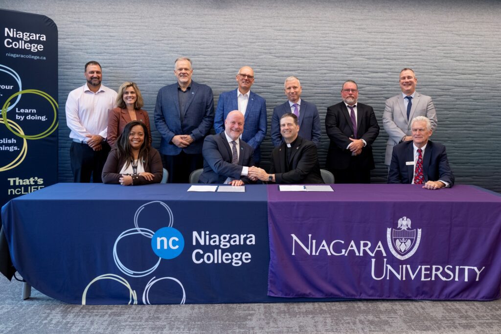 Sean Kennedy, president of Niagara College, shakes hands with the Rev. James J. Maher, C.M., president of Niagara University, upon signing a dual admission and articulation agreement on Sept. 14, 2026.